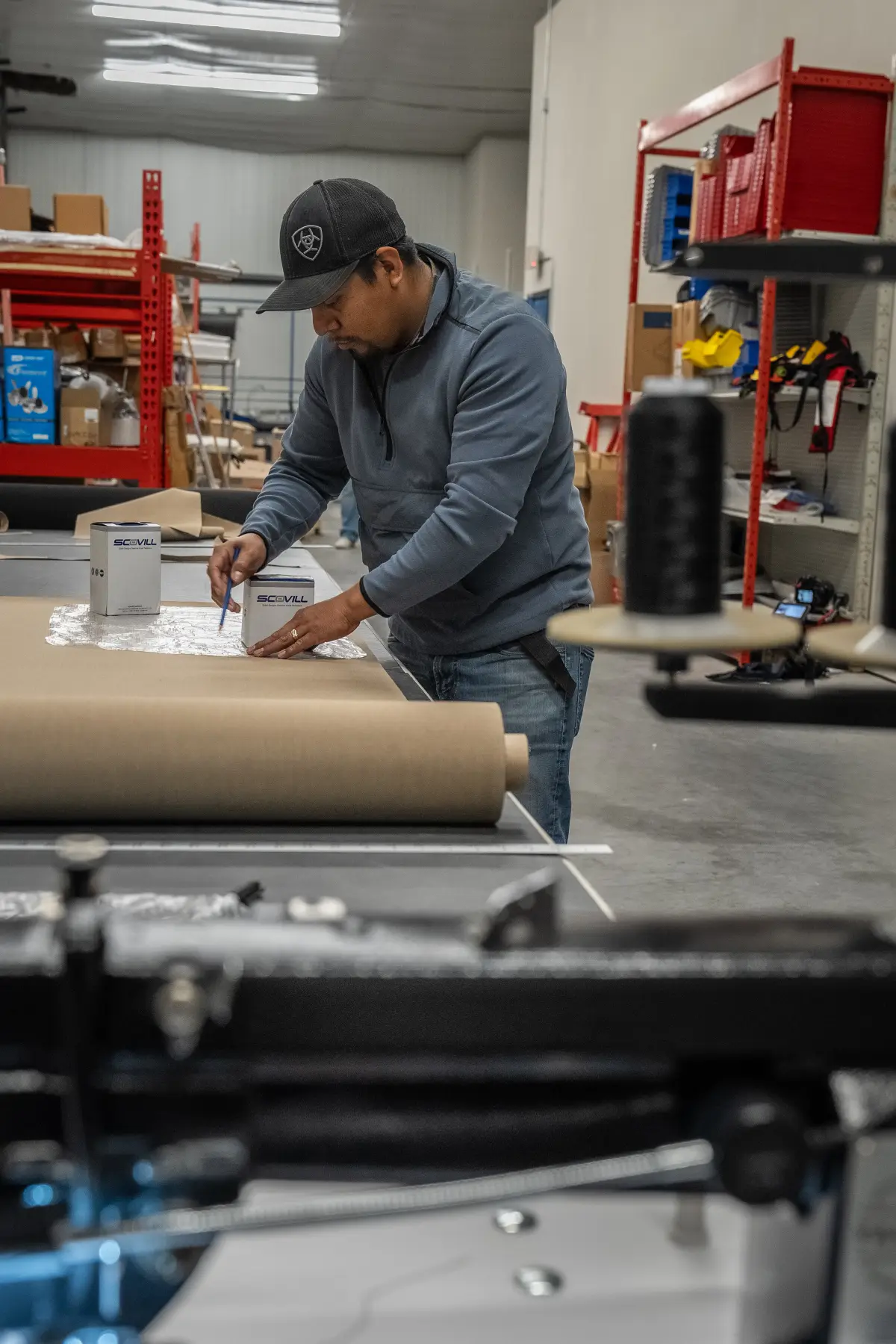 A Big Thunder Marine craftsman laying out a pattern on the canvas shop bench