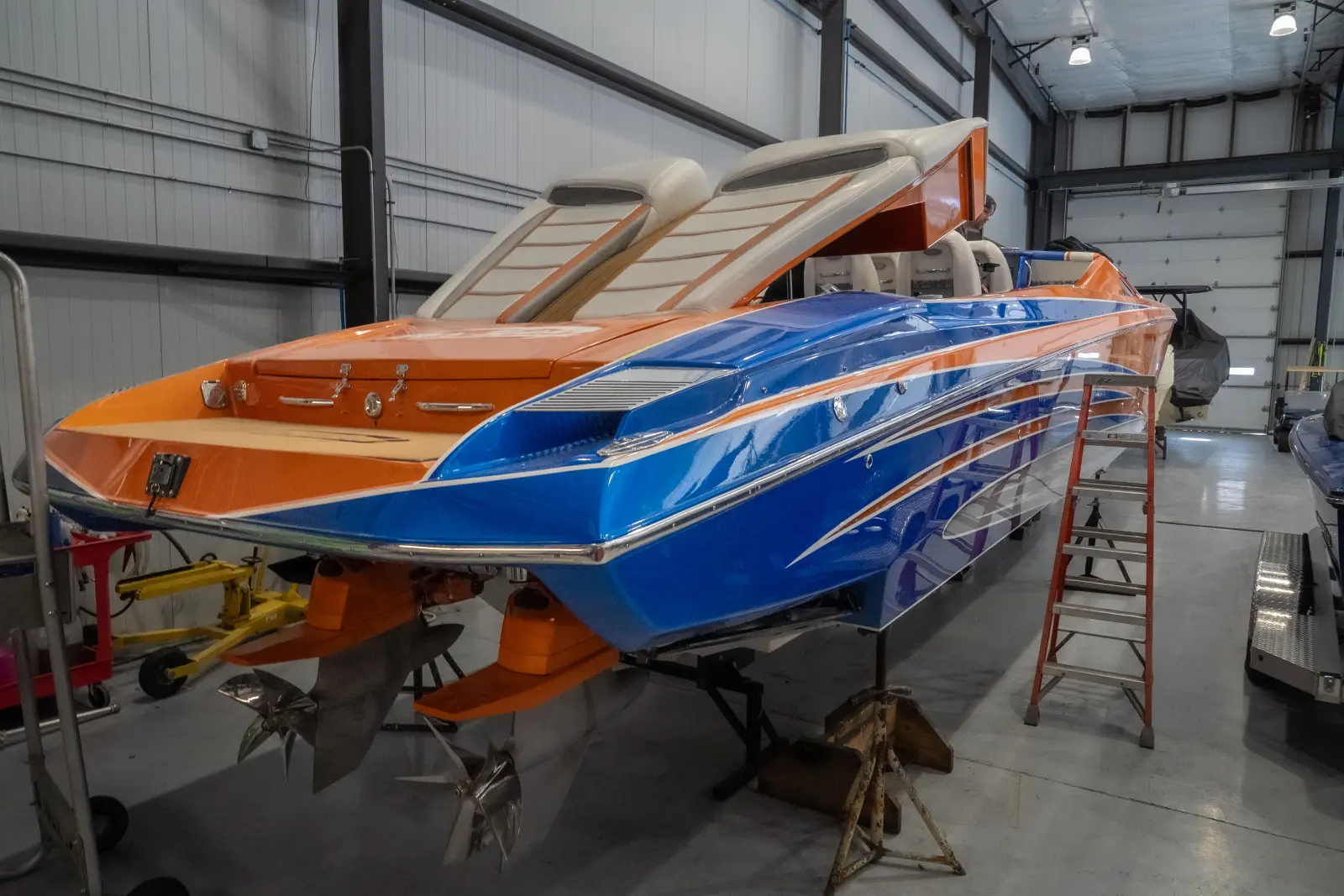 A freshly finished orange and blue performance boat in the Big Thunder Marine service shop