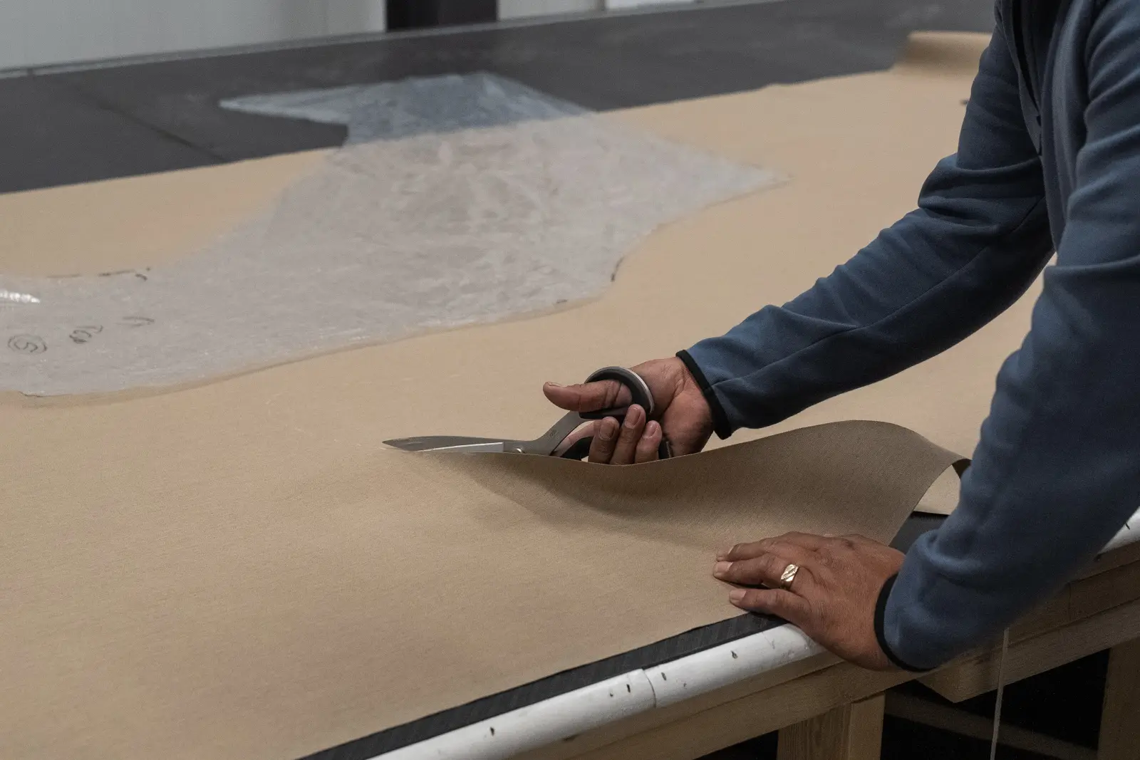 A Big Thunder Marine craftsman cutting a clear vinyl pattern for custom isinglass