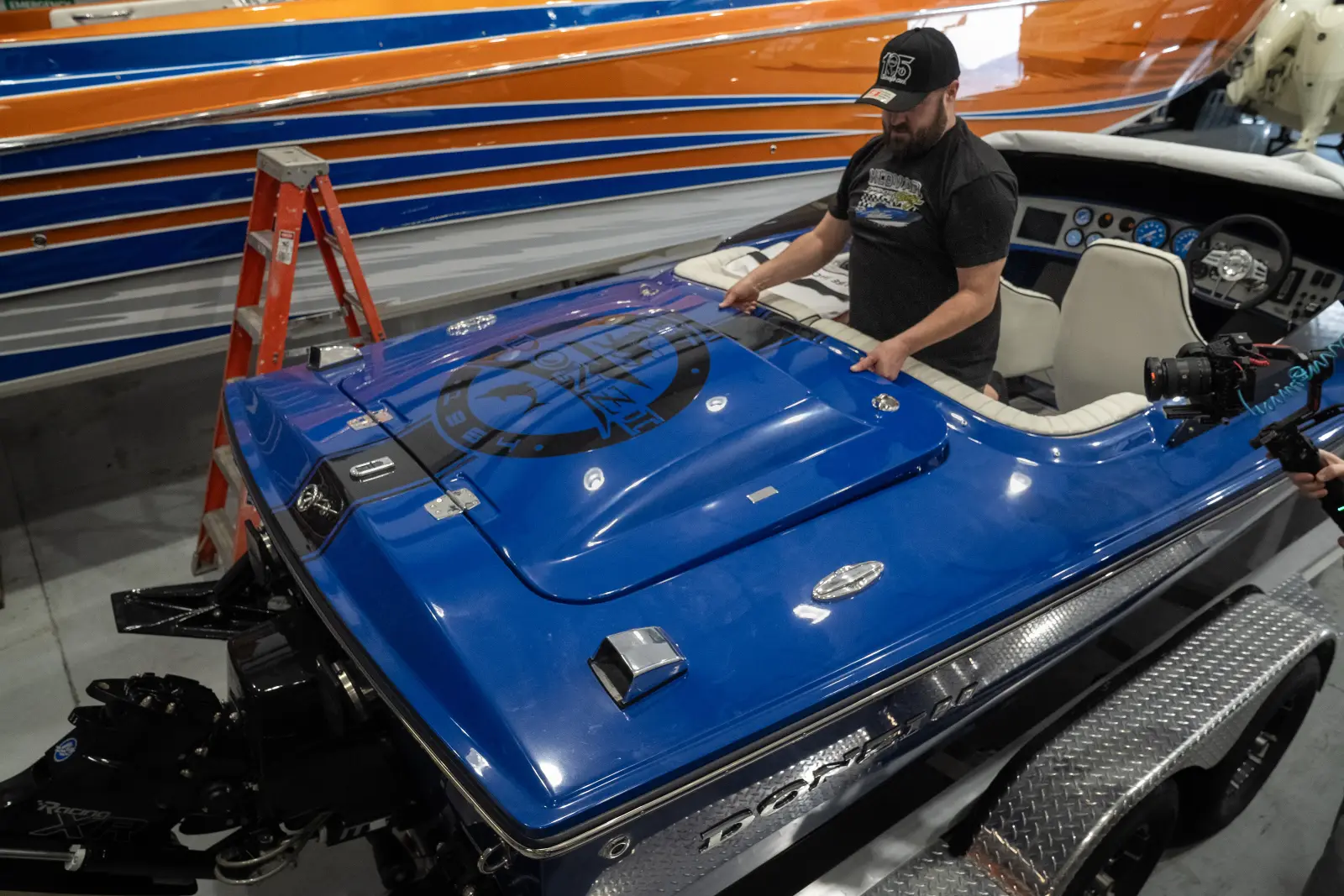 A Big Thunder Marine technician working in the cockpit of a blue performance boat